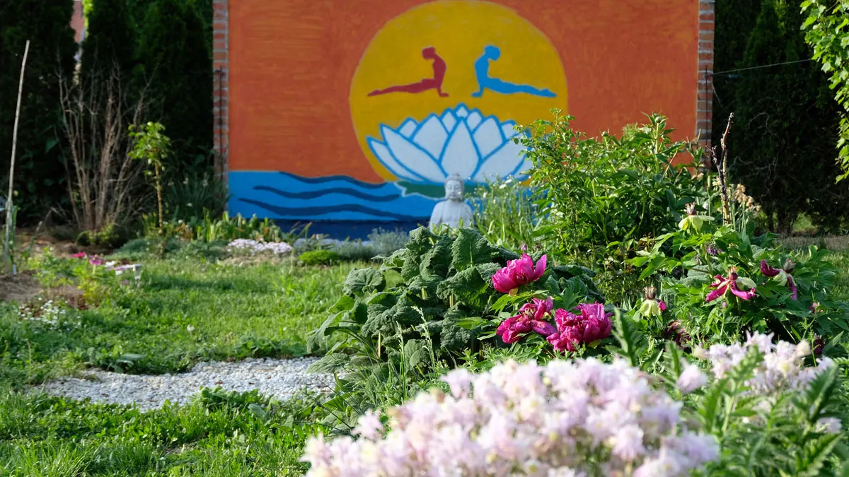 Vrt Yoga centra Lotos s muralom: sunce, lotos i dvije figure u položaju kobre